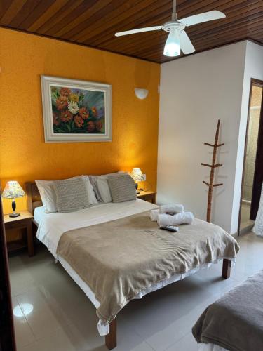 a bedroom with a bed and a painting on the wall at Pousada Sereia de Geriba in Búzios