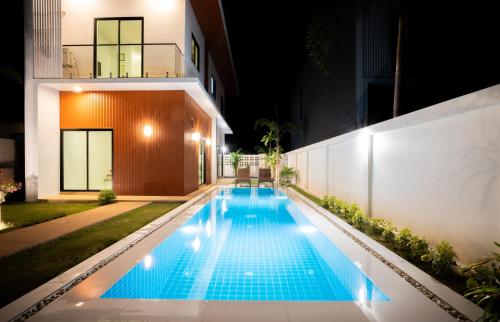 a swimming pool in the backyard of a house at night at Krabi Private Pool Villa 1 by Belcarrra Spaces in Ban Khlong Haeng