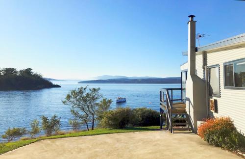 a house with a view of the water at Surveyor's Cottage in Surveyors Bay