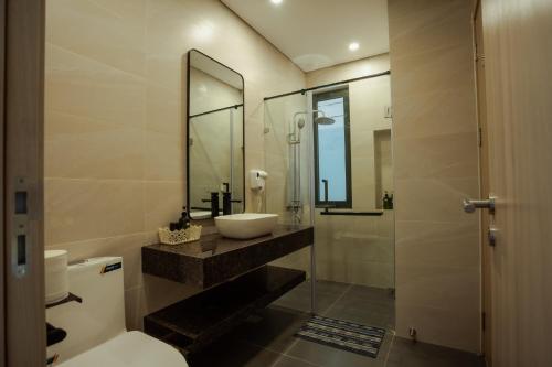 a bathroom with a sink and a toilet and a mirror at VILLA VENUS -Khu B Không mất vé cổng - tại Khu du lịch sinh thái Đại Lải in Thanh Cao