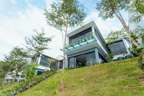 a house on top of a hill with trees at VILLA VENUS -Khu B Không mất vé cổng - tại Khu du lịch sinh thái Đại Lải in Thanh Cao