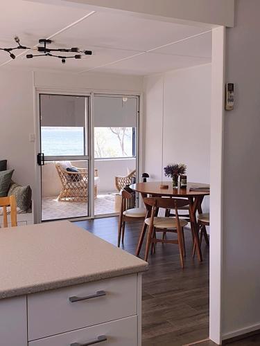 a kitchen and living room with a table and a dining room at Surveyor's Cottage in Surveyors Bay
