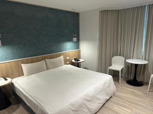 a bedroom with a white bed and a green wall at 響悅汽車旅館 in Xinwu