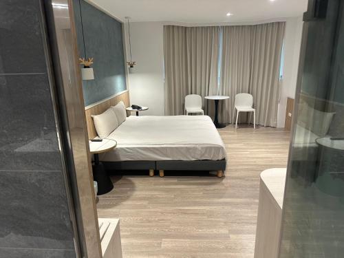 a bedroom with a bed and a table and chairs at 響悅汽車旅館 in Xinwu