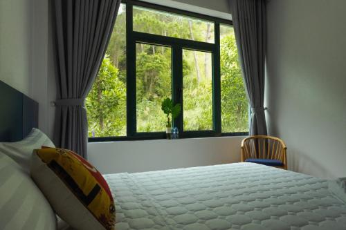 a bedroom with a bed and a large window at VILLA VENUS -Khu B Không mất vé cổng - tại Khu du lịch sinh thái Đại Lải in Thanh Cao