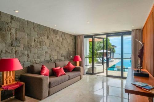 a living room with a couch with red pillows at Chayanika 3 BR Private Pool Villa With Sea View ZN149 in Ujung