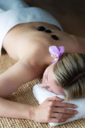 a woman with a flower on her head sleeping on a towel at Heartwood Farm Byron Bay Luxury Farm Stay in Federal