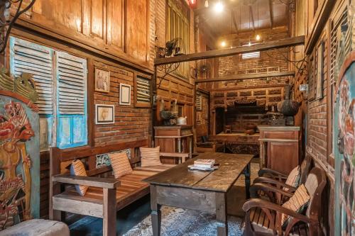 a room with wooden walls and a table and chairs at TwoSpaces Living at Bunga Desa, Jimbaran in Jimbaran