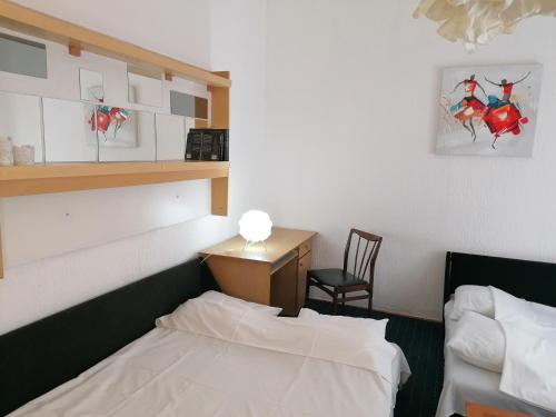a room with two beds and a desk and a chair at RiverRetreat in Belgrade
