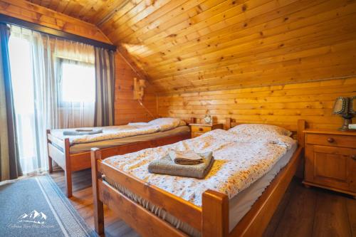 a bedroom with two beds in a wooden cabin at Rum Haz in Borzont