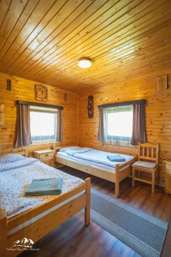 a bedroom with two beds in a wooden cabin at Rum Haz in Borzont