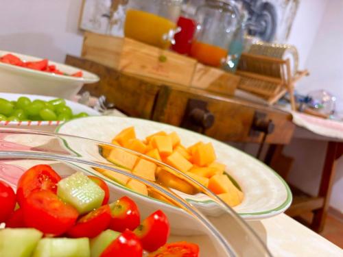 a table with two plates of fruit and vegetables at Nonna Nara Bed & Breakfast in Grosseto