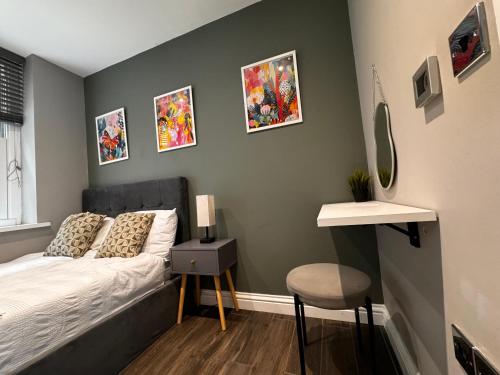 a bedroom with a bed and some pictures on the wall at Beautiful Brighton Apartment, 5min walk to beach in Brighton & Hove