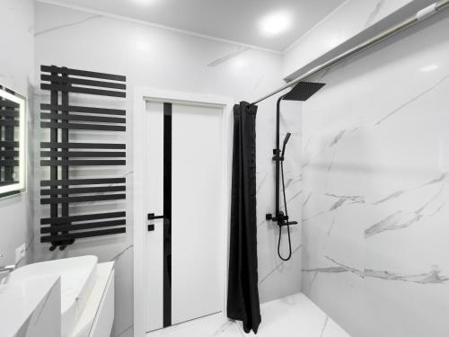 een witte badkamer met douche en wastafel bij RentWill apartments Silver in Chişinău
