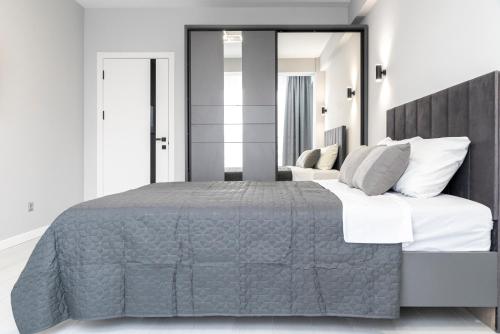 een slaapkamer met een groot bed en een grote spiegel bij RentWill apartments Silver in Chişinău