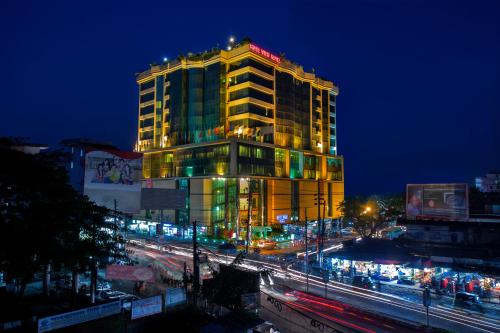 a tall building with lights on top of it at night at Rose View Hotel in Sylhet