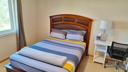 a bedroom with a bed and a desk with a computer at Garden view room with private bathroom in Calgary
