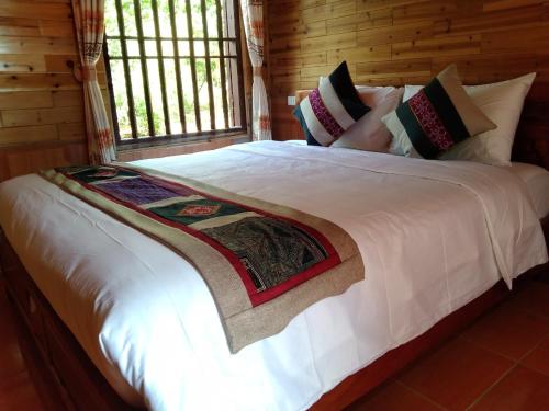 a bedroom with a large white bed with pillows at A Lìn Homestay Bắc Hà in Bắc Hà