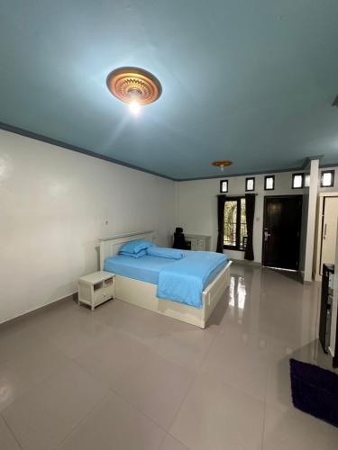 a bedroom with a bed in a white room at Hotel Any Lestari in Huu