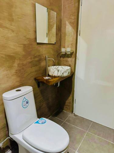a bathroom with a white toilet and a sink at Bohol Island Homestay in Dauis