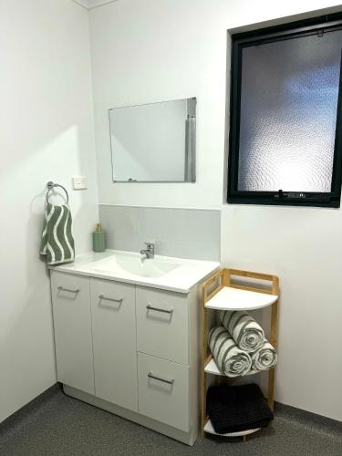 a bathroom with a sink and a mirror at Red Emu Motel in Perenjori