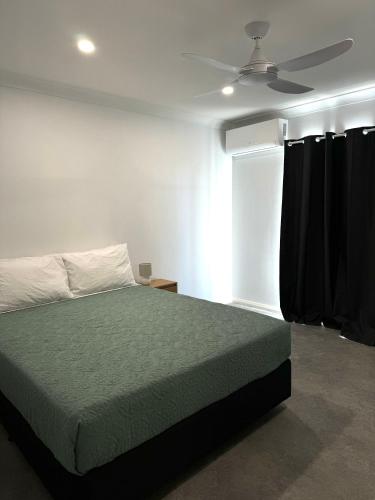 a bedroom with a bed and a ceiling fan at Red Emu Motel in Perenjori