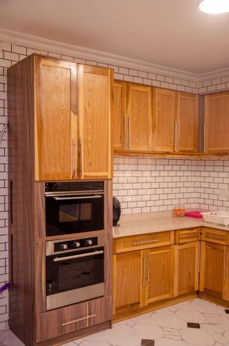 a kitchen with wooden cabinets and an oven at The Noble Villa, Ikorodu, Lagos in Ikorodu
