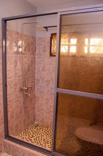 a shower with a glass door in a bathroom at The Noble Villa, Ikorodu, Lagos in Ikorodu