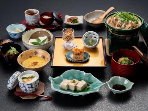 a table topped with bowls and plates of food at Kageyu in Isehara