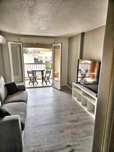 un salon avec un canapé et une télévision dans l'établissement Port frejus à 2 pas de la mer, à Fréjus