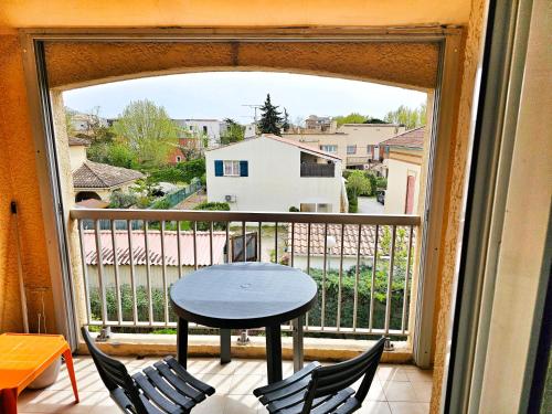 une chambre avec un balcon avec une table et des chaises dans l'établissement Port frejus à 2 pas de la mer, à Fréjus