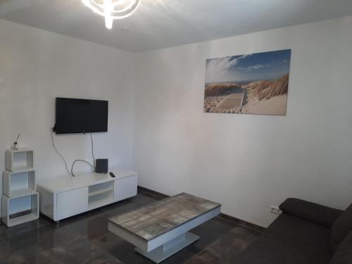 a living room with a couch and a tv on a wall at Wohnen wie Zuhause in Abstatt