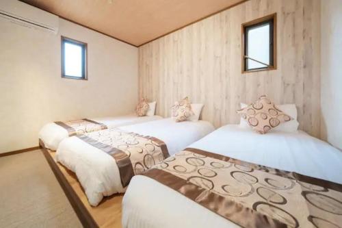 a room with three beds in it with windows at Kawaguchi Asama Jinjakan - Diamond Yu in Azagawa
