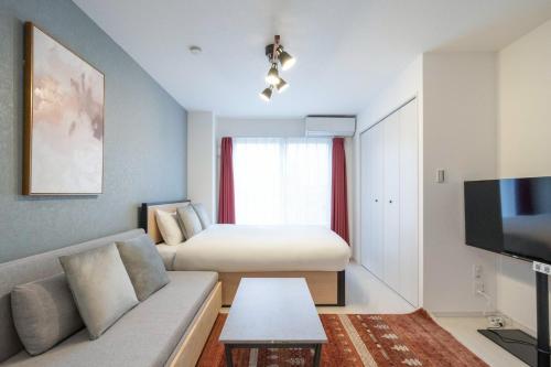 a hotel room with a couch and a bed at Rufura Fukusima in Osaka