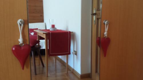 a room with a table with red hearts hanging from the door at Casa Monteggia in Dobbiaco