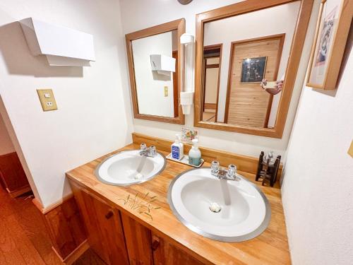 a bathroom with two sinks and a mirror at Koguma no ie in Nozawa Onsen