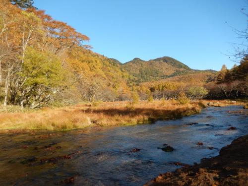 a river in the middle of a field with mountains at Nikko Astraea Hotel in Nikko