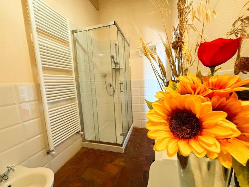 a vase of flowers in a bathroom with a shower at Nonna Nara Bed & Breakfast in Grosseto