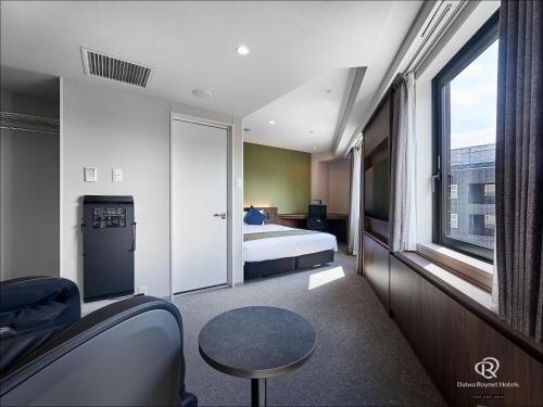a hotel room with a bed and a window at Daiwa Roynet Hotel Kyoto-Hachijoguchi in Kyoto
