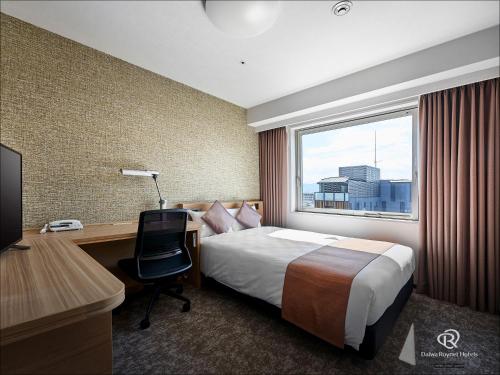 a hotel room with a bed and a desk and a window at Daiwa Roynet Hotel Kyoto-Hachijoguchi in Kyoto
