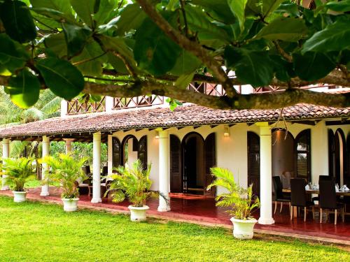 a house with potted plants in front of it at Villa Ocean's Edge in Ranna