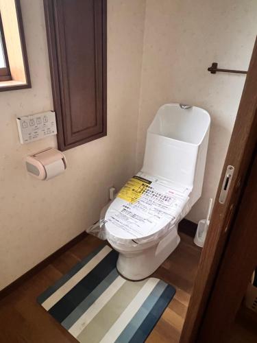 a bathroom with a toilet with a sign on it at フルブルーム in Nasu-yumoto