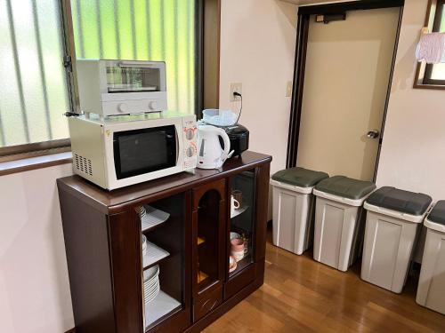 a room with a tv and a microwave on a cabinet at フルブルーム in Nasu-yumoto