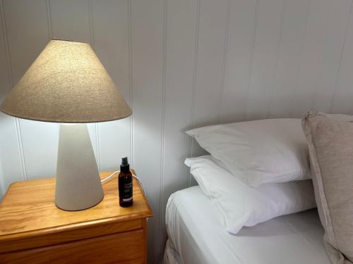 una lámpara en una mesita de noche junto a una cama en Nest - charming, comfortable coastal villa, en Port Fairy