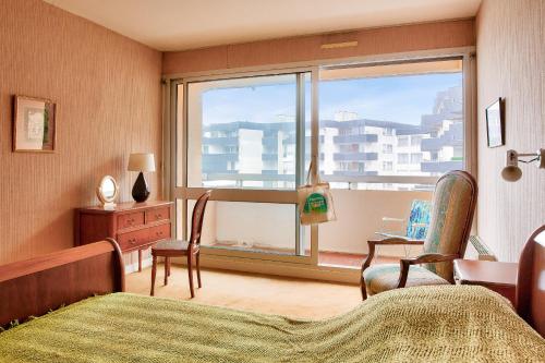 une chambre avec un lit et une fenêtre avec vue dans l'établissement À 200m de la plage, appartement vue mer pour 4, à Bénodet