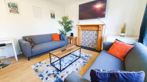 a living room with a couch and a table at Cheerful 4-bedroom house in Cheltenham