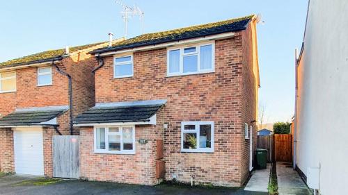 a brick house with solar panels on it at Cheerful 4-bedroom house in Cheltenham