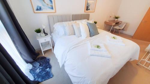a bedroom with a white bed with two towels on it at Lovely Flat In Kiln Close With Free Parking in Gloucester
