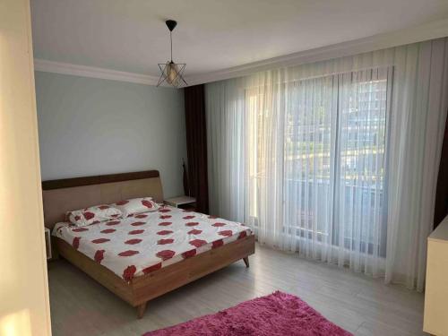 a bedroom with a bed and a large window at Plaja yakın konforlu aile yuvası in Piraziz