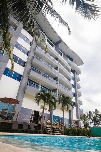 a hotel with a swimming pool in front of a building at Puerto Azul Hotel in Puntarenas